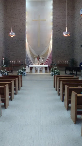 View of altar at St. Joseph Chapel with wooden pews on each side